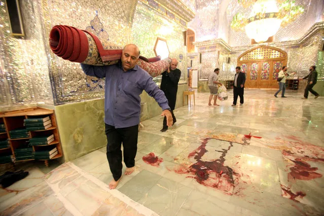 Workers clean up the scene following an armed attack at the Shah Cheragh mausoleum in the Iranian city of Shiraz on October 26, 2022. At least 15 people were killed in an attack on a key Shiite Muslim shrine in southern Iran, state media said, with the Islamic State group claiming the assault. The attack carried out by an armed “terrorist” during evening prayers at the Shah Cheragh mausoleum also wounded at least 19 people, state television said. (Photo by ISNA News Agency/AFP Photo)