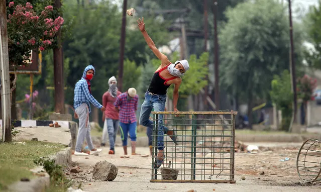 A man throws a rock at security personnel following the death of Irfan Ahmed, who according to local media died after being hit by a tear gas canister fired by security forces, in Srinagar, August 22, 2016. (Photo by Cathal McNaughton/Reuters)