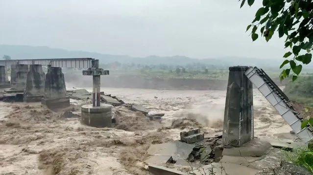 A general view of a bridge that collapsed following heavy rains in Kangra, Himachal Pradesh, India on August 20, 2022 in this screen grab obtained from a video. (Photo by ANI via Reuters)