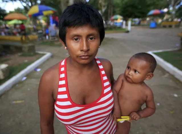 A Colombian Nukak Maku Indian woman holds her baby in a park in San Jose del Guaviare of Guaviare province, September 4, 2015. (Photo by John Vizcaino/Reuters)
