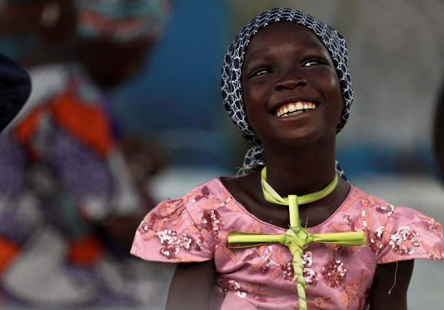 A girl smiles while listening to a sermon during the Palm Sunday service and procession at the Regina Mundi Catholic Church in Mushin, Lagos, Nigeria on April 13, 2025. (Photo by Sodiq Adelakun/Reuters)