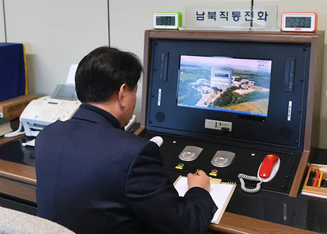 A South Korean government official checks the direct communications hotline to talk with the North Korean side at the border village of Panmunjom in Paju, South Korea, Wednesday, January 3, 2018. North Korean leader Kim Jong Un reopened a key cross-border communication channel with South Korea on Wednesday, another sign easing animosity between the rivals even as Kim traded combative threats of nuclear war with President Donald Trump. (Photo by Yonhap via AP Photo)