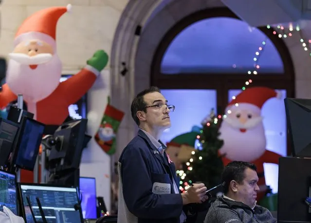 Traders work at the Closing Bell with Christmas decorations on the floor of the New York Stock Exchange in New York, New York, USA, on 12 December 2022. The Dow Jones Industrial Average closed the day up over 500 points. (Photo by Justin Lane/EPA/EFE)