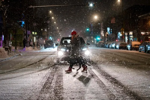 A person crosses a street in the Mile End, a borough in Montreal, Quebec, Canada, as the snow comes down on December 22, 2022. A “once-in-a-generation” winter storm with temperatures as low as -40 degrees Fahrenheit caused Christmas travel chaos in the United States on Thursday, with thousands of flights cancelled and major highways closed. (Photo by Andrej Ivanov/AFP Photo)