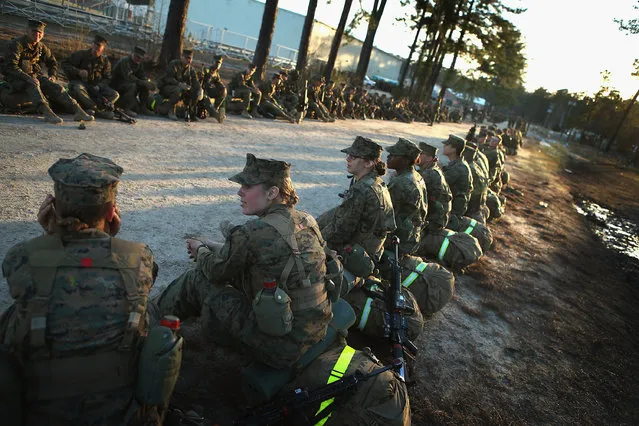 Male and female Marines prepare to head out on a 15-kilometer night march with male and female Marines during Marine Combat Training (MCT) on February 21, 2013 at Camp Lejeune, North Carolina.  Since 1988 all non-infantry enlisted male Marines have been required to complete 29 days of basic combat skills training at MCT after graduating from boot camp. MCT has been required for all enlisted female Marines since 1997. About six percent of enlisted Marines are female.  (Photo by Scott Olson)