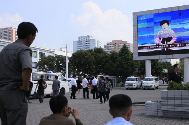 North Koreans watch a news report regarding a nuclear test on a large screen outside the Pyongyang Station in Pyongyang, North Korea, Friday, September 9, 2016. North Korea said Friday it conducted a “higher level” nuclear warhead test explosion, which it trumpeted as finally allowing it to build “at will” an array of stronger, smaller and lighter nuclear weapons. (Photo by Jon Chol Jin/AP Photo)
