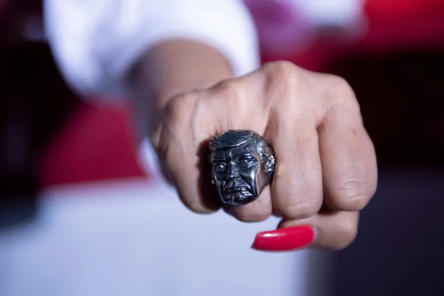 A supporter shows a ring featuring the face of US President Donald Trump during a campaign rally at the Minden-Tahoe airport in Minden (50miles/80km south of Reno), Nevada on September 12, 2020. (Photo by Brendan Smialowski/AFP Photo)