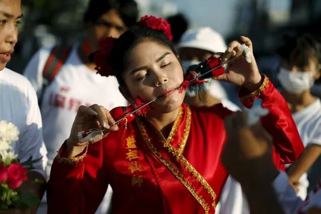 A devotee of the Chinese Ban Tha Rue shrine walks with spikes pierced through her cheeks during a procession celebrating the annual vegetarian festival in Phuket, Thailand, October 17, 2015. (Photo by Jorge Silva/Reuters)