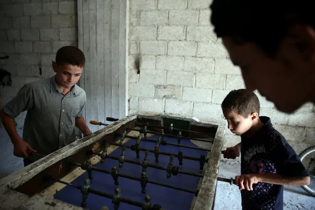 Children play table football on the last day of Eid al-Adha celebrations in the rebel held besieged town of Hamouriyeh, eastern Ghouta, near Damascus, Syria September 15, 2016. (Photo by Bassam Khabieh/Reuters)