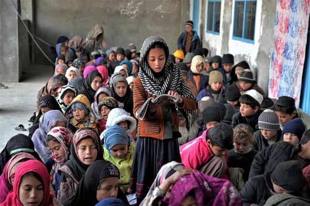 In this photograph taken on January 22, 2023, Afghan children take lessons at an open classroom in Dand district of Kandahar province. (Photo by Sanaullah Seiam/AFP Photo)