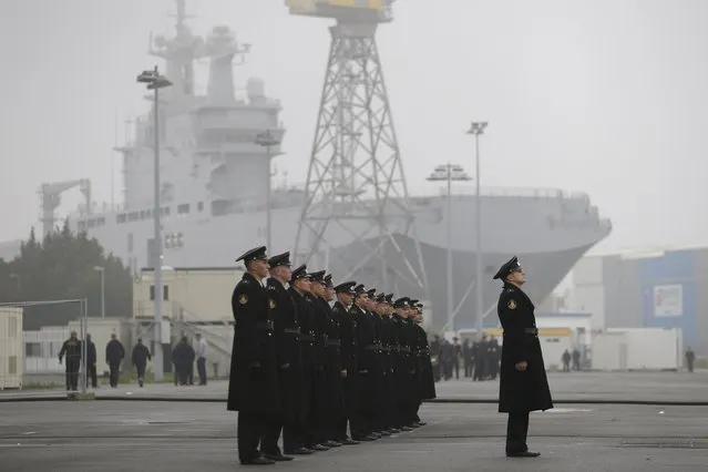 Russian sailors stand in formation in front of the Mistral-class helicopter carrier Vladivostok at the STX Les Chantiers de l'Atlantique shipyard site in Saint-Nazaire, western France, November 25, 2014. France suspended indefinitely on Tuesday delivery of the first of two Mistral helicopter carrier warships to Russia, citing conflict in eastern Ukraine where the West accuses Moscow of fomenting separatism. (Photo by Stephane Mahe/Reuters)