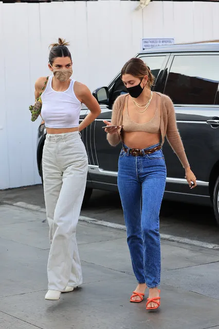 Kendall Jenner and Hailey Bieber show their friendship is growing stronger as they enjoy a fun LA girls shopping trip together on October 7, 2020. The supermodels looked stunning and showed off their incredible figures and toned abs as they stepped out in almost identical outfits. Kendall, 24, wore a white crop top, white jeans and white heels while Hailey, 23, opted for a skimpy bra top, cardigan, blue denim jeans and red heels. The BFF’s had their hair tied up and both wore masks as they visited stores in Santa Monica, CA. (Photo by Rachpoot/ASTRO/The Mega Agency)