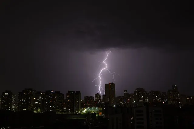 Lightning strikes over buildings in Istanbul, Turkey, Wednesday, August 24, 2022. (Photo by Khalil Hamra/AP Photo)