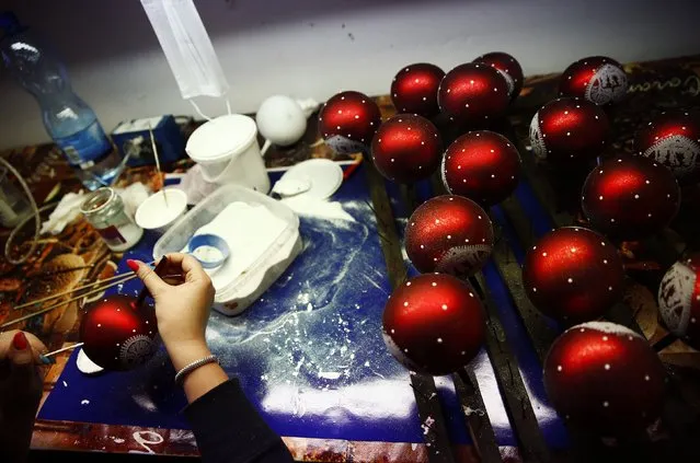 A worker paints Christmas decorations on glass baubles at the Silverado manufacture of hand-blown Christmas ornaments in the town of Jozefow outside Warsaw December 2, 2014. (Photo by Kacper Pempel/Reuters)