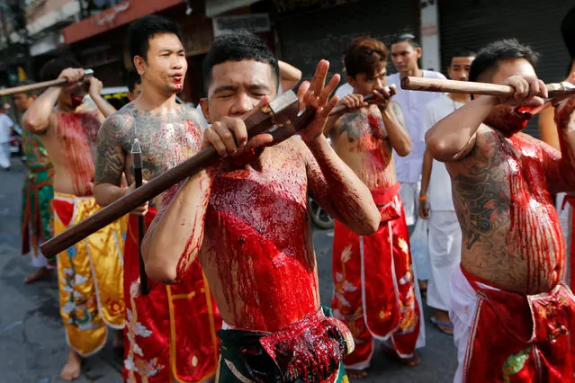 Devotees of the Chinese Samkong Shrine walk while cutting their tongues with axes during a procession celebrating the annual vegetarian festival in Phuket, Thailand October 4, 2016. (Photo by Jorge Silva/Reuters)