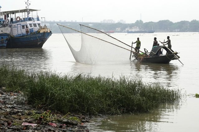Fishermen in a country boat haul the Hooghly River to catch fish for their livelihood, in Kolkata, India, Tuesday, August 5, 2025. (Photo by Bikas Das/AP Photo)