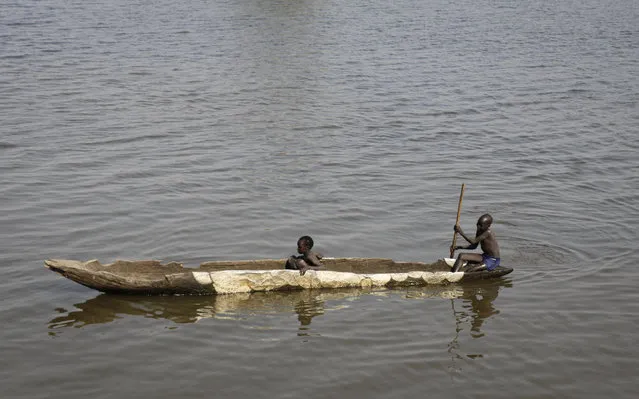 In this photo taken Thursday, January 18, 2018, children fish from a dugout canoe in Akobo town, one of the last rebel-held strongholds in South Sudan. (Photo by Sam Mednick/AP Photo)