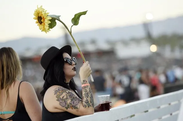 Nicole Demarbiex of Palm Desert, Calif. waits for Neil Young's performance to start on day 2 of the 2016 Desert Trip music festival at Empire Polo Field on Saturday, October 8, 2016, in Indio, Calif. (Photo by Chris Pizzello/Invision/AP Photo)