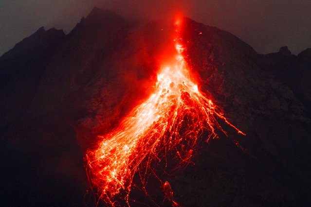 This long exposure photo taken on May 14, 2023 shows Mount Merapi spewing lava onto its slopes as seen from Srumbung, Central Java. (Photo by Devi Rahman/AFP Photo)