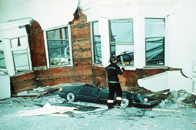 A house, tilted but not fallen down yet, stands near the car of its owner, crushed by debris and cracked San Francisco streets on October 18, 1989. (Photo by AP Photo)
