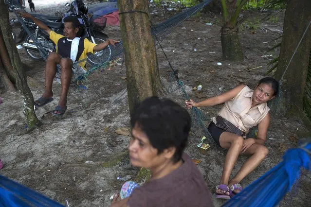 Local people rest in hammocks in Ban Nam Khem, December 13, 2014. (Photo by Damir Sagolj/Reuters)