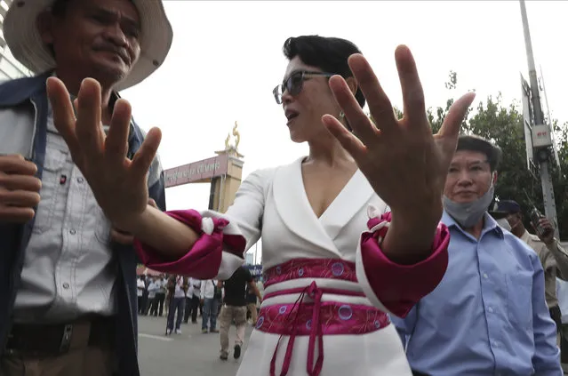 Theary Seng, center, a Cambodian-American lawyer gestures as she enters the Phnom Penh Municipal Court, in Phnom Penh, Cambodia, Thursday, November 26, 2020. A Cambodian court on Thursday began hearing the cases of nearly 130 opponents and government critics charged with treason for taking part in nonviolent political activities over the past three years, in what one of them described as a sham trial. Theary Seng, who has long been one of the most outspoken critics of Hun Sen and his government, is one of the best known defendants living in Cambodia. (Photo by Heng Sinith/AP Photo)