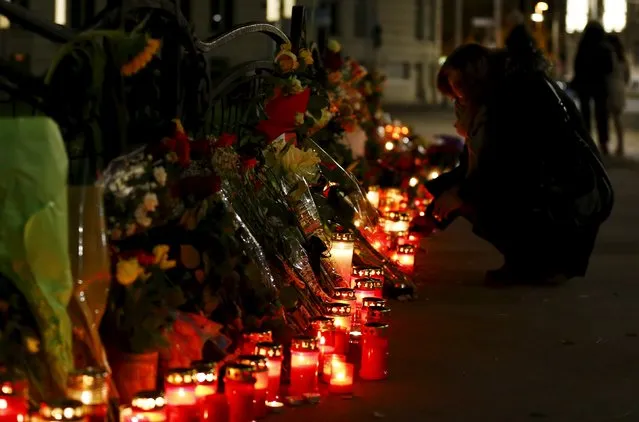 A woman lights a candle for the victims of the Paris attacks in front of the French embassy in Vienna, Austria, November 14, 2015. (Photo by Leonhard Foeger/Reuters)