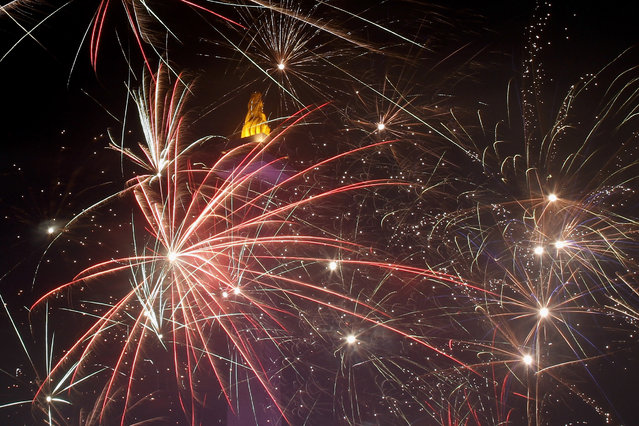 Fireworks explode over the National Monument on December 31, 2014 in Jakarta, Indonesia. Thousands of people gather in Jakarta, Indonesia's capital city to see the new year celebrations. (Photo by Syamsul Bahri Muhammad/Getty Images)