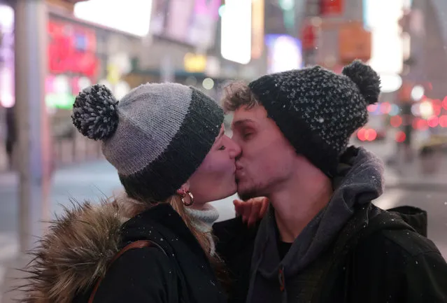 People kiss as snow begins to fall in Times Square during a Nor'easter, during the coronavirus disease (COVID-19) pandemic in the Manhattan borough of New York City, New York, U.S., December 16, 2020. (Photo by Jeenah Moon/Reuters)