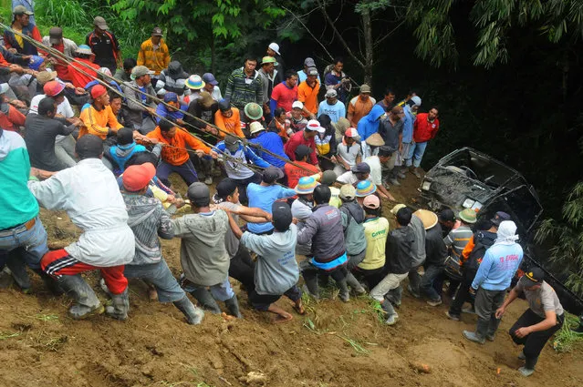 Residents work together to pull a pickup truck that fell into a ravine in Selo village in Boyolali, Indonesia, October 26, 2016. (Photo by Aloysius Jarot Nugroho/Reuters/Antara Foto)