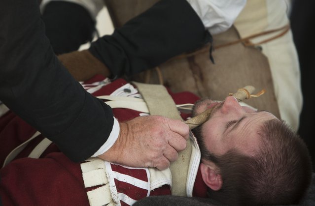 Mark Miller of West Monroe, Louisiana, plays the part of an injured American fighter being treated for a gunshot wound following a reenactment of the Battle of New Orleans in the War of 1812, marking its  bicentennial in Chalmette, Louisiana January 10, 2015. (Photo by Lee Celano/Reuters)