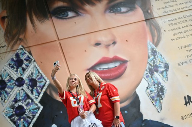Fans of US mega-star Taylor Swift pose for a selfie photograph next to a mural of the performer created by street artists MurWalls, outside Wembley Stadium in London on August 15, 2024, ahead of the first of five concerts she is playing at the stadium. Taylor Swift returns to the stage in London on Thursday to end the European leg of her “Eras” tour, a week after her Vienna concerts were cancelled due to a suicide attack plot. Around 90,000 fans will again pack London's Wembley Stadium for the first date in the five-day run, with additional ticket checks and restrictions in place. (Photo by Justin Tallis/AFP Photo)