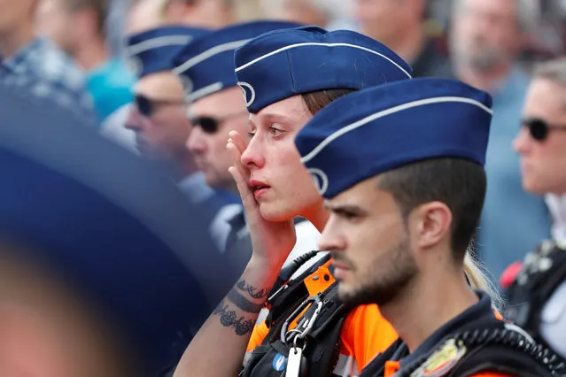 A policewoman reacts during a minute of silence in Liege, Belgium May 30, 2018. An attack that killed two policewomen and a male bystander in the eastern Belgian city of Liege on May 29, 2018 amount to “terrorist murder”, prosecutors spokesman said during a press conference. Also the attacker is suspected of killing one other person on the eve of his rampage, according to prosecutors on May 30, 2018. Belgian police is investigating how the gunman known for contacts with Islamist extremists came to launch a terror attack. (Photo by Yves Herman/Reuters)