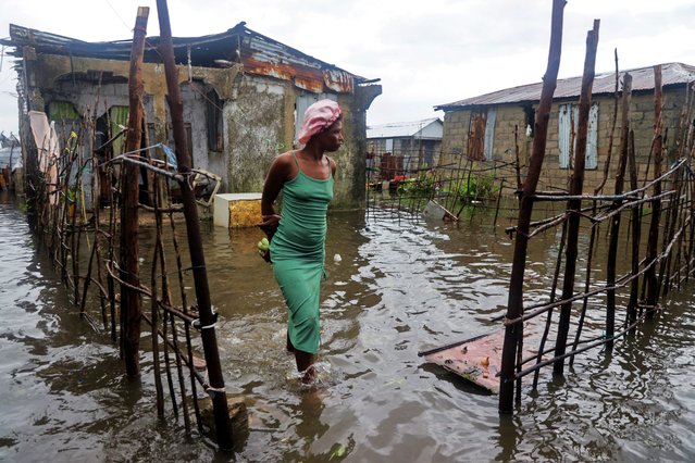 A woman stands outside her home after heavy rains from the outer bands of Hurricane Melissa flooded parts of Les Cayes, Haiti, on October 29, 2025. (Photo by Patrice Noel/Reuters)