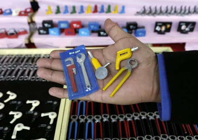 A man holds miniature tools during the “Alasitas” fair in La Paz January 24, 2015. (Photo by David Mercado/Reuters)