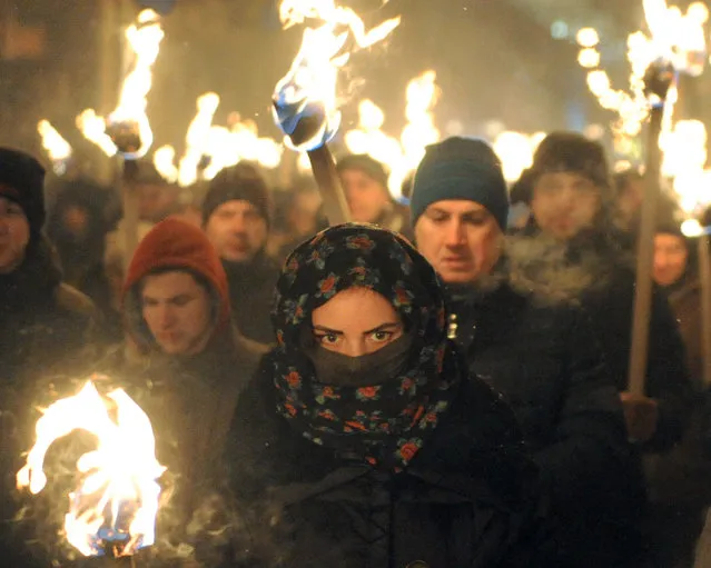 Nationalists hold torches during a march in KLviv on January 1, 2016, as they mark the 107th anniversary of the birth of Stepan Bandera. Bandera was a Ukrainian politician and one of the leaders of Ukrainian national movement in western Ukraine, who headed the Organization of Ukrainian Nationalists (OUN). (Photo by Yuriy Dyachyshyn/AFP Photo)