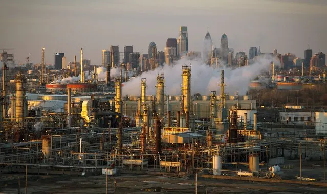 The Philadelphia Energy Solutions oil refinery owned by The Carlyle Group is seen at sunset in front of the Philadelphia skyline March 24, 2014. (Photo by David M. Parrott/Reuters)