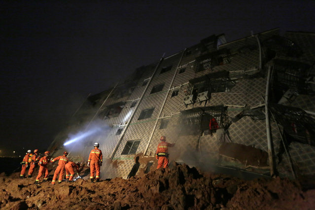 Rescuers work on the collapsed factory buildings brought down by a midday landslide in Shenzhen in south China's Guangdong province, 20 December 2015. At least 41 people are missing after a landslide in the southern Chinese city of Shenzhen buried multiple houses and caused at least one to collapse, the Chinese news agency Xinhua reported 20 December. (Photo by How Hwee Young/EPA)