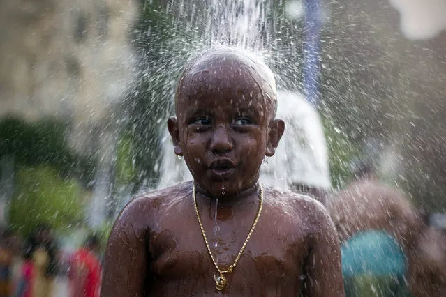 A Hindu devotee gets showered as part of a cleaning ritual before his pilgrimage during the Thaipusam festival in Kuala Lumpur, Malaysia, Tuesday, Feb. 3, 2015. Thaipusam, which is celebrated in honor of Hindu god Lord Murugan, is an annual procession by Hindu devotees seeking blessings, fulfilling vows and offering thanks. (AP Photo/Joshua Paul)