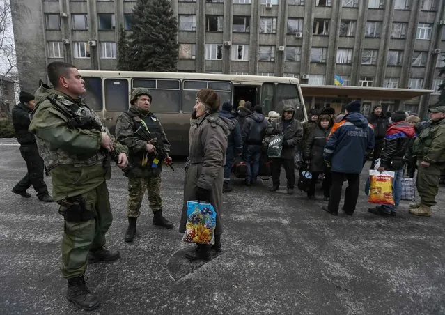 Members of the Ukrainian armed forces assist local residents onto a bus, to flee the military conflict, in Debaltseve, eastern Ukraine, February 6, 2015. (Photo by Gleb Garanich/Reuters)