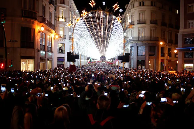 People use mobile phones to take pictures as Christmas lights are turned on to mark the start of the Christmas season at Marques de Larios street in downtown Malaga, southern Spain, November 24, 2016. (Photo by Jon Nazca/Reuters)