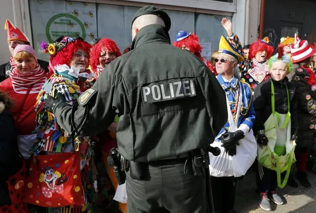 Carnival revellers talk to a police officer during the traditional Rose Monday carnival parade in the western German city of Duesseldorf February 16, 2015. (Photo by Wolfgang Rattay/Reuters)