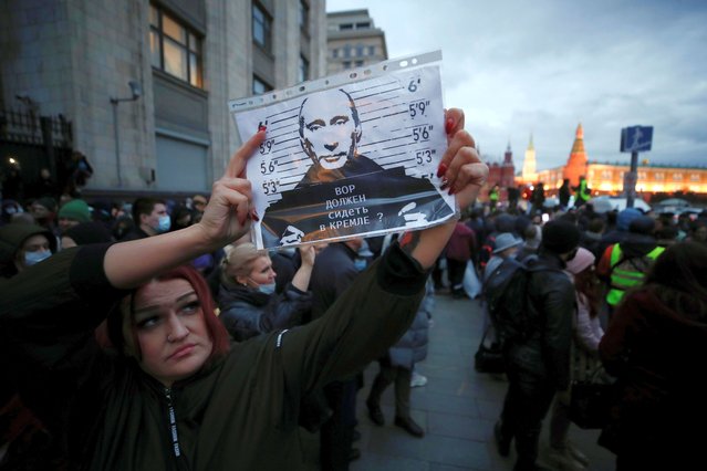 A woman holds up an image of Russian President Vladimir Putin that reads “Should the thief be in the Kremlin?” during a rally in support of jailed Russian opposition politician Alexei Navalny in Moscow, Russia, April 21, 2021. (Photo by Maxim Shemetov/Reuters)