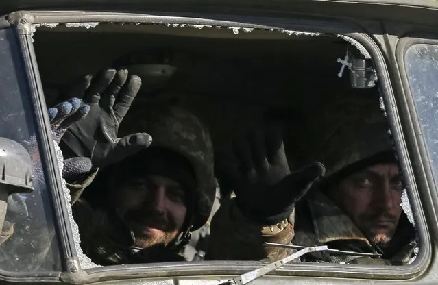 Ukrainian servicemen ride on a military vehicle as they leave an area around Debaltseve, eastern Ukraine near Artemivsk, February 18, 2015. (Photo by Gleb Garanich/Reuters)