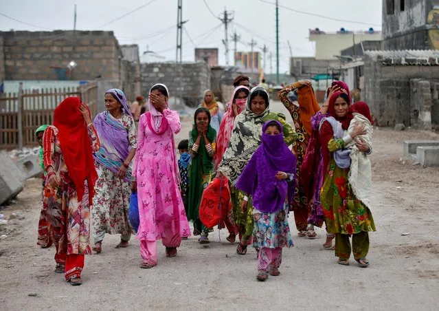 Women with their children leave their houses and evacuate to a safer place ahead of Cyclone Tauktae in Veraval in the western state of Gujarat, India, May 17, 2021. (Photo by Amit Dave/Reuters)