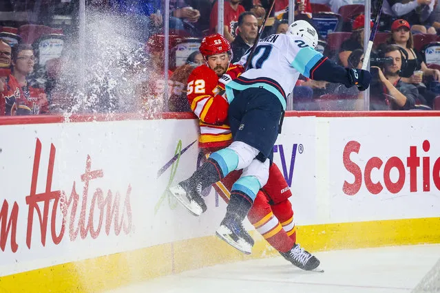 Seattle Kraken right wing Eeli Tolvanen (20) checks into the boards Calgary Flames defenseman MacKenzie Weegar (52) during the first period at Scotiabank Saddledome in Calgary, Alberta on September 25, 2023. (Photo by Sergei Belski/USA TODAY Sports)