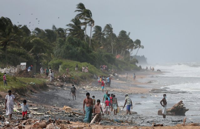 Villagers search for cargos on a beach spilled from MV X-Press Pearl container ship which caught fire in the seas off the Colombo Harbour in Ja-Ela, Sri Lanka on May 26, 2021. (Photo by Dinuka Liyanawatte/Reuters)