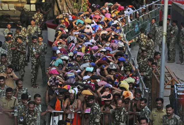 Devotees wait to worship at the Sabarimala temple, one of the world's largest Hindu pilgrimage sites, Kerala state, India, Monday, November 5, 2018. The historic Sabarimala temple which had barred women age 10 to 50 from entering the temple, opened to Hindu pilgrims for a day Monday evening. The last time it was opened, conservative protesters blocked women of menstruating age from going to the temple, defying a recent ruling from India's top court to let them enter. (Photo by Manish Swarup/AP Photo)