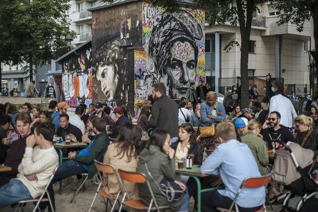 People socialize and drink at a cafe terrace in Paris, France, Saturday, June 5, 2021. (Photo by Lewis Joly/AP Photo)