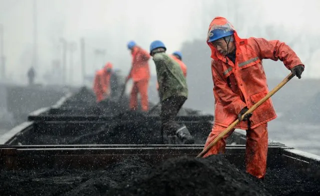 Workers work on the coal carriages at a railway station in the snow in Jiujiang in central China's Jiangxi province 22 January 2016. A powerful cold front is sweeping through China, bringing snow to the south and disrupting traffic. (Photo by Hu Guolin/EPA)